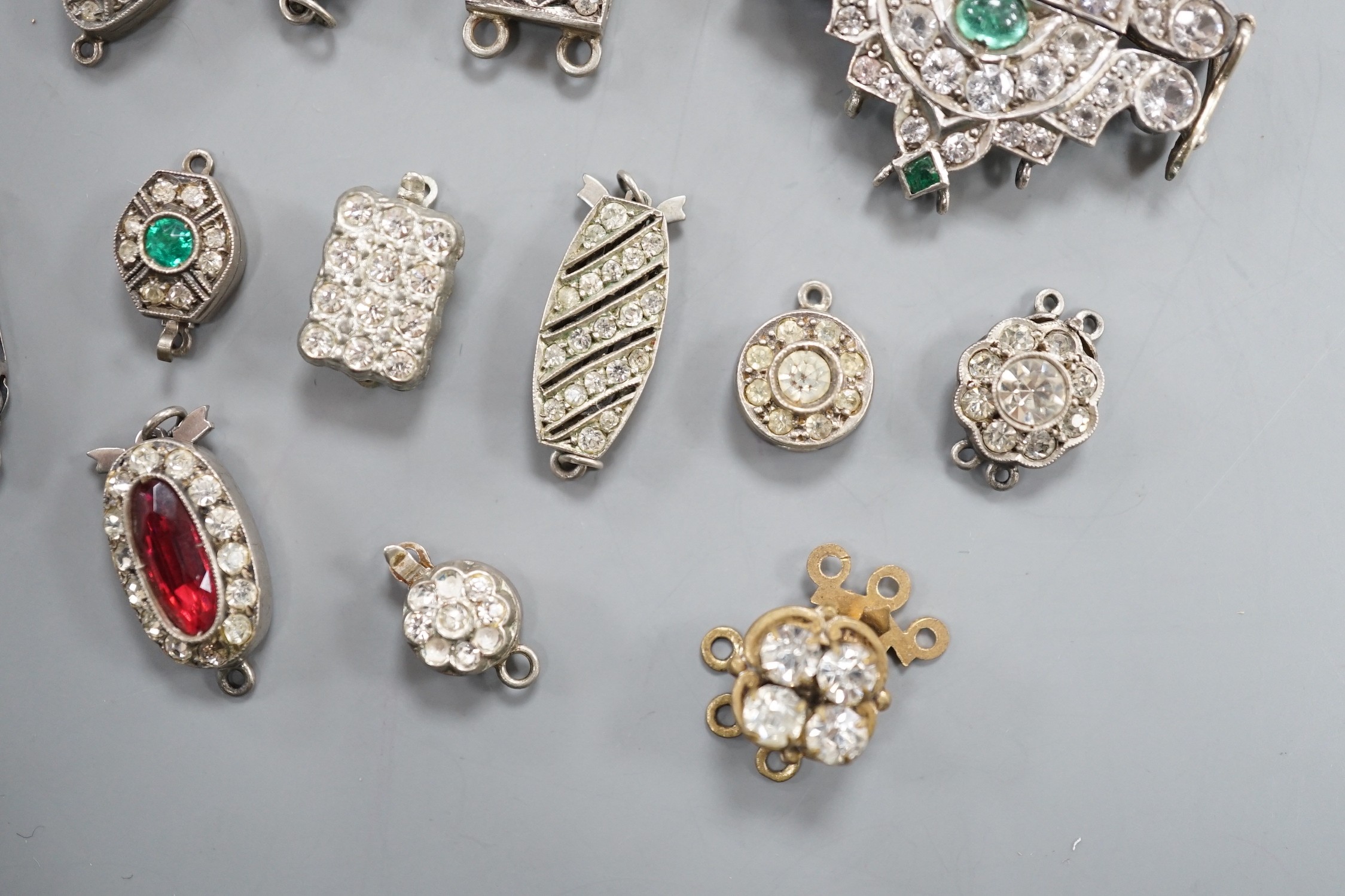 A small group of assorted white or base metal and paste set clasps.